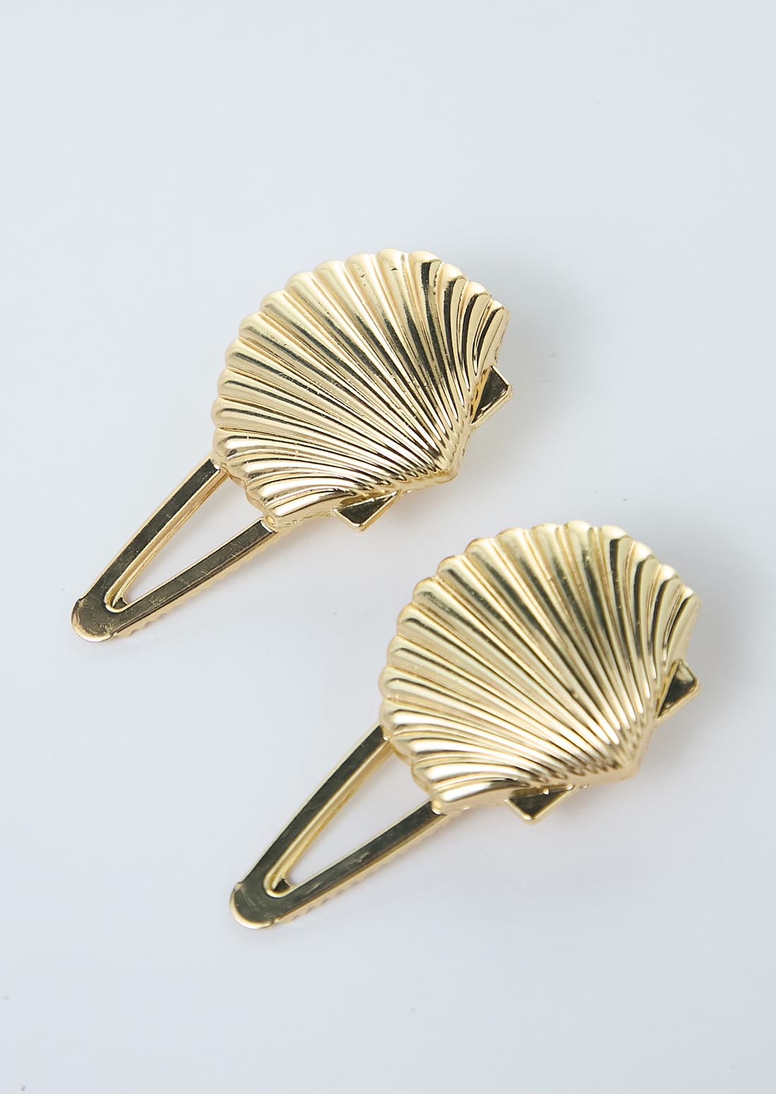 Duo de pinzas doradas en forma de concha para el cabello