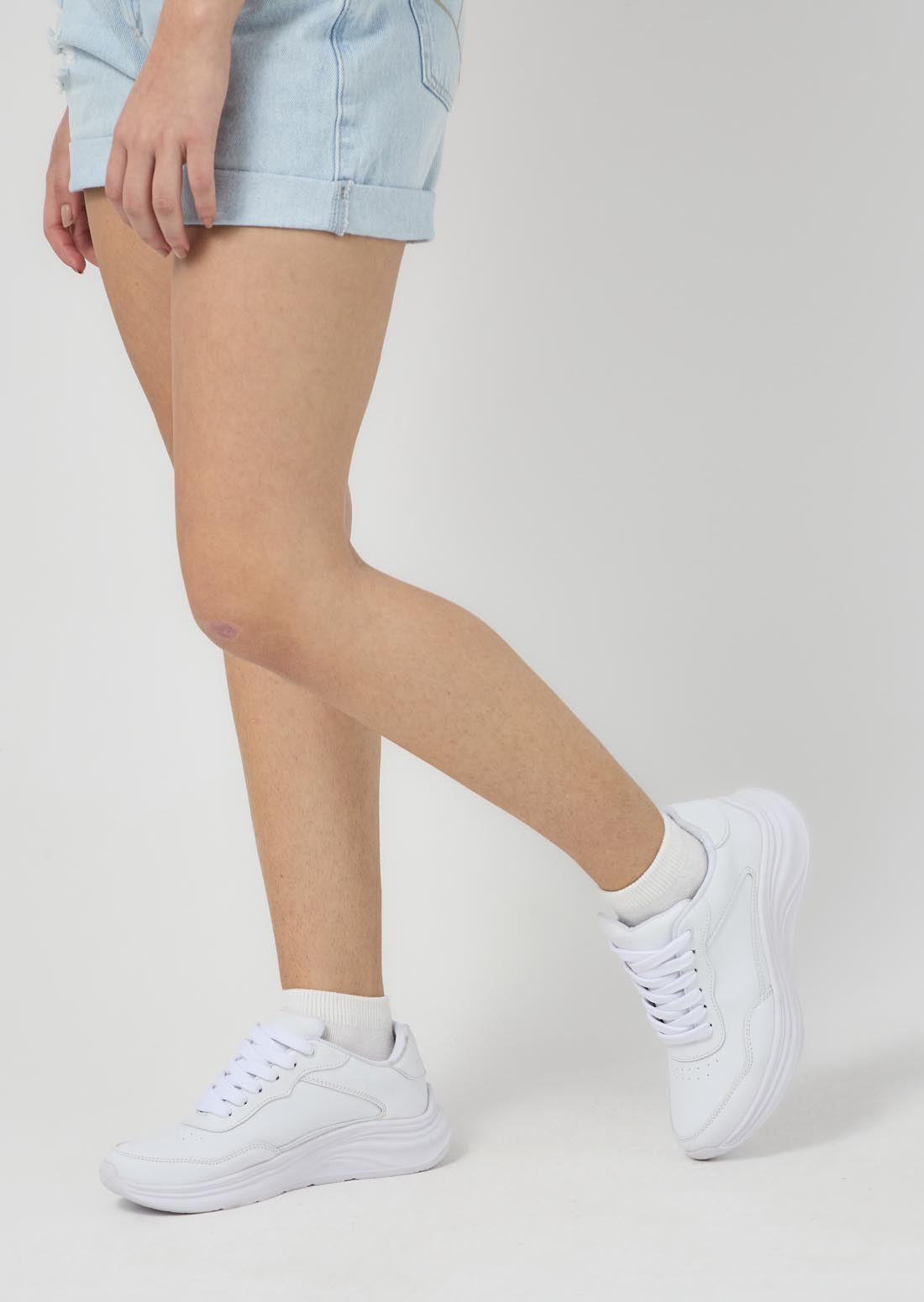 Tenis blancos con líneas escolares